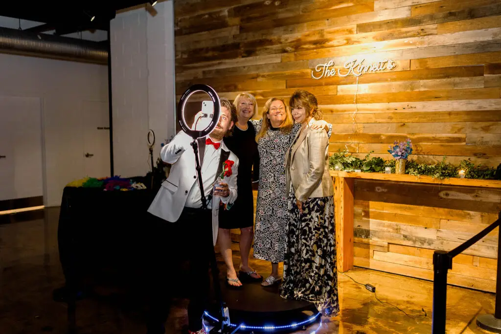 A group of happy guests posing for a 360-degree photo booth at an Indianapolis team-building event.