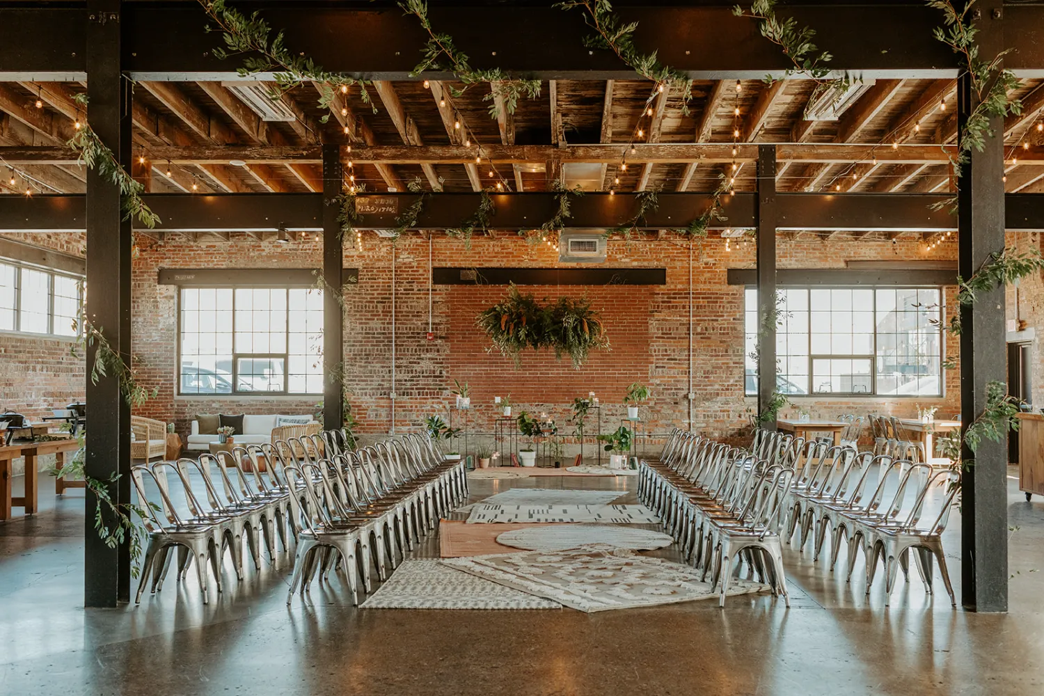 A wedding aisle setup inside INDUSTRY, showcasing the venue’s exposed brick, high ceilings, and industrial-modern design.