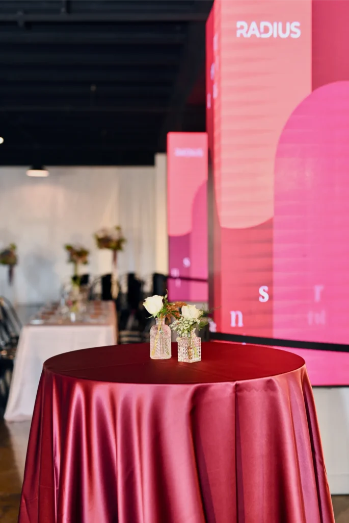 Corporate cocktail hour at Radius event venue in downtown Indianapolis with branded AV pillar displays